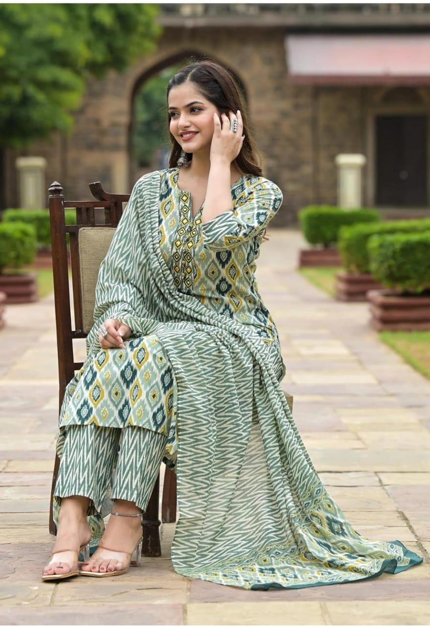 Smiling woman seated outdoors wearing green printed viscose rayon kurta pant dupatta set with matching sandals
