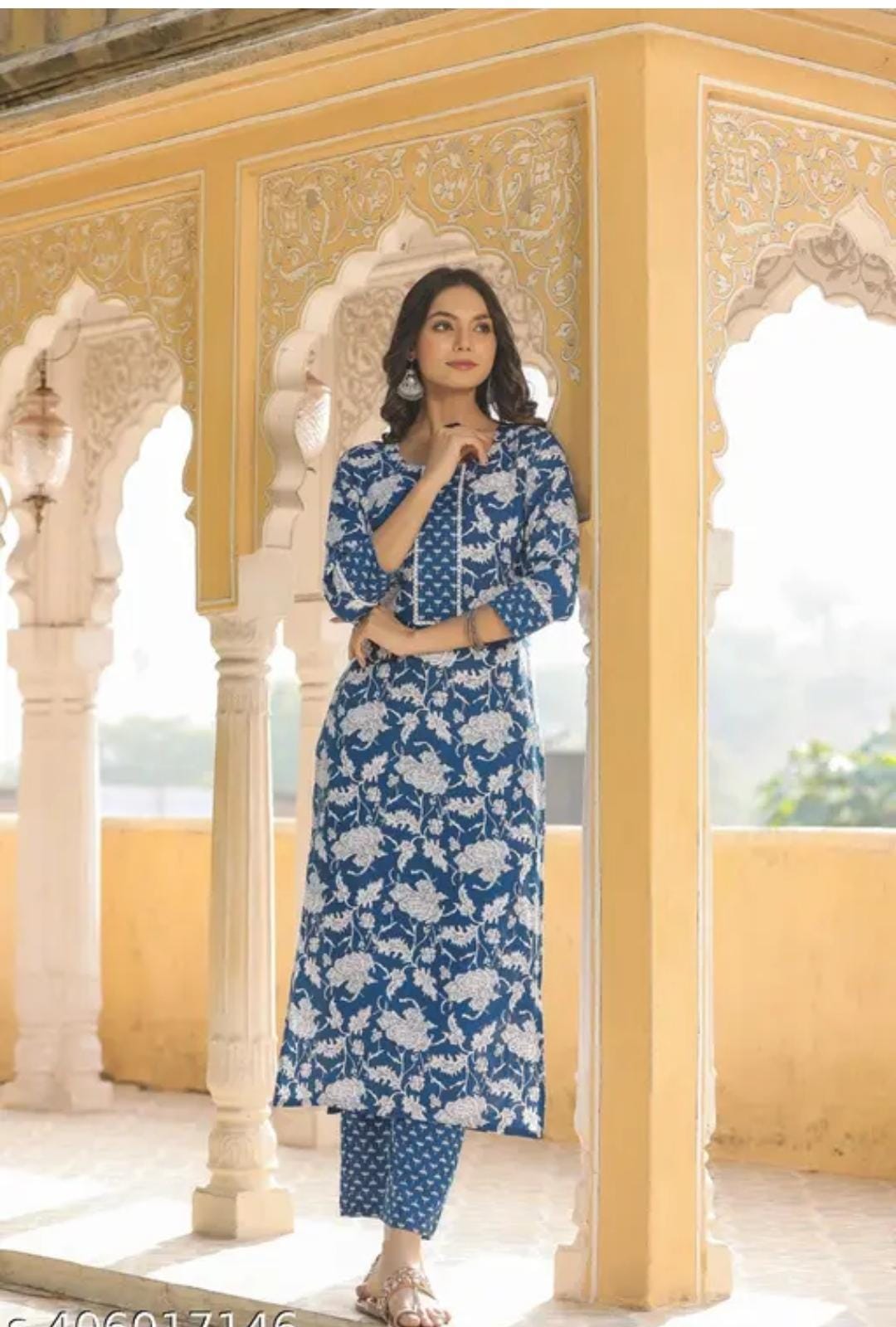 Woman modeling blue floral round neck kurta with pants set in traditional archway setting for womens kurta sets