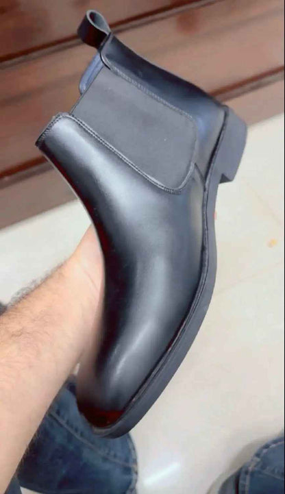 Black slip on boots for men with sleek leather design and elastic side panels for easy wear