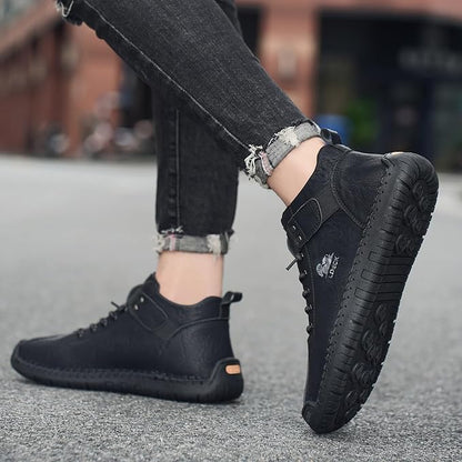 Casual black boots for men with lace-up design and rugged sole worn with black jeans