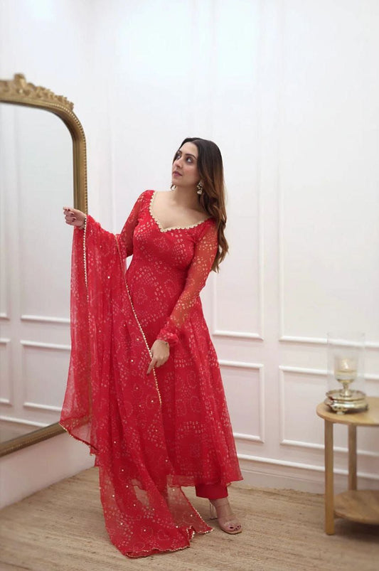Woman wearing a flowing red bandhani gown for women with long sleeves scalloped neckline and matching dupatta