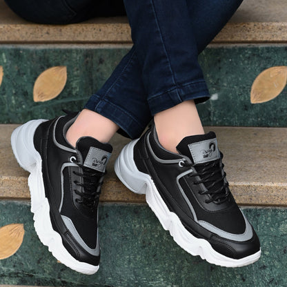 Black and grey sport shoes for men with white chunky soles worn with dark jeans