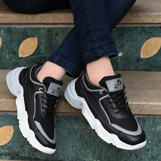 Black and grey sport shoes for men with white chunky soles worn with dark jeans