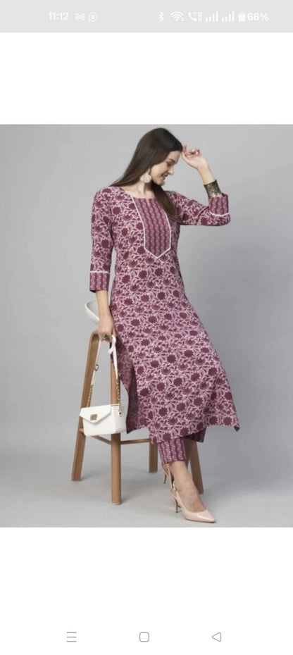 Model wearing maroon printed floral cotton kurta set for women with matching pants three quarter sleeves and white handbag