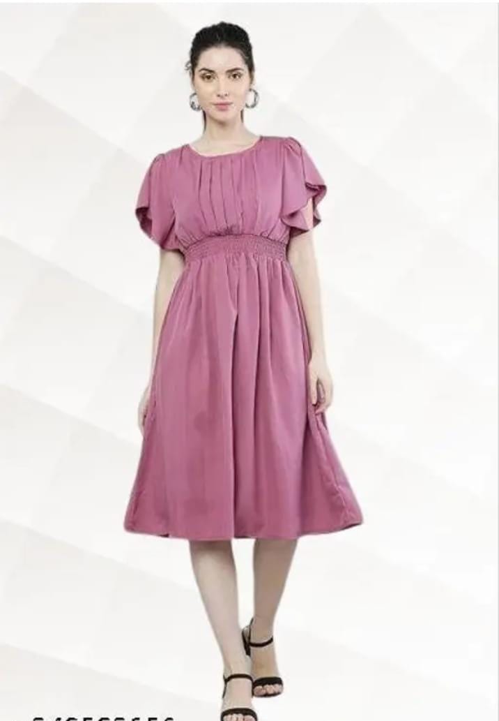 Model wearing a knee length pink fit and flare dress for women with smocked waist flutter sleeves pleated bodice