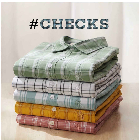 Stack of folded multi color check shirts for men in green white blue yellow and red shades