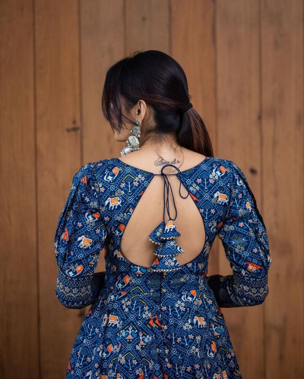 Back view of a woman wearing a printed georgette gown for women with open back and tie detail