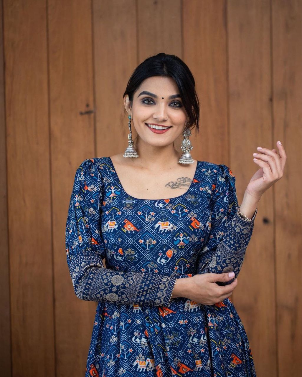 Smiling woman wearing a printed georgette gown for women with colorful elephant and floral patterns